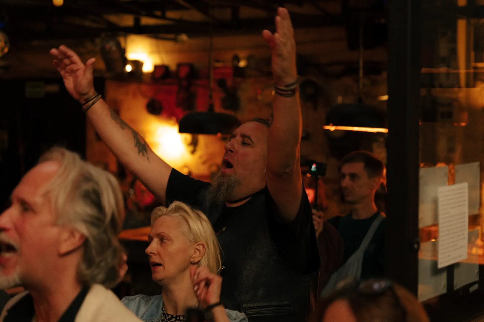 Audience cheering with raised hands at the concert