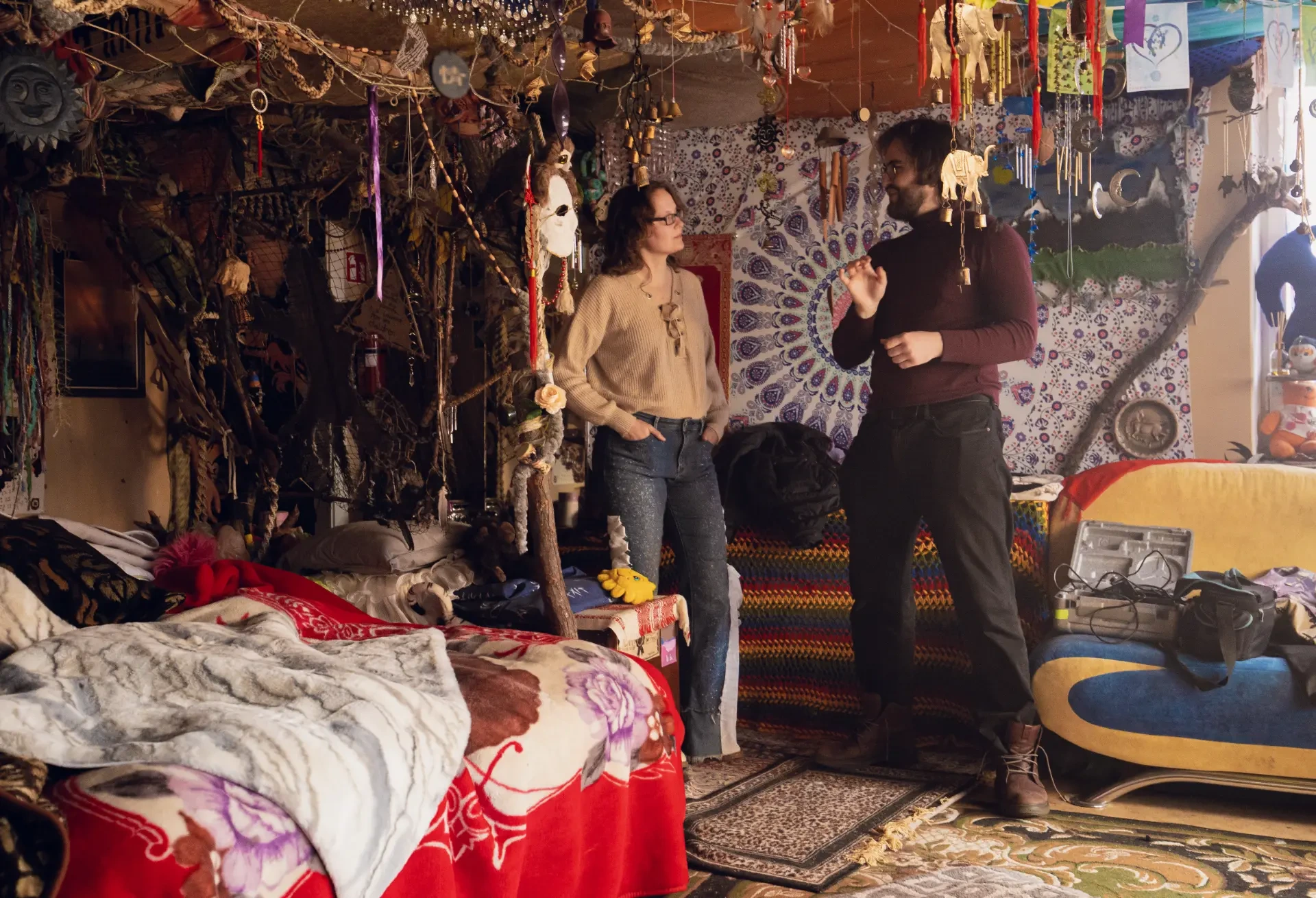 Two Film Camp participants talking in a room filled with artwork and hanging decorations