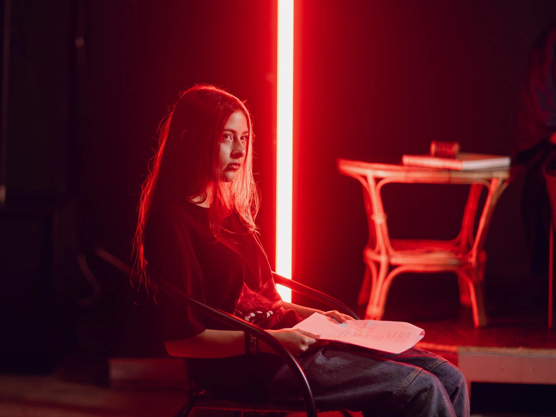 Film Camp participant holding script pages under red lighting