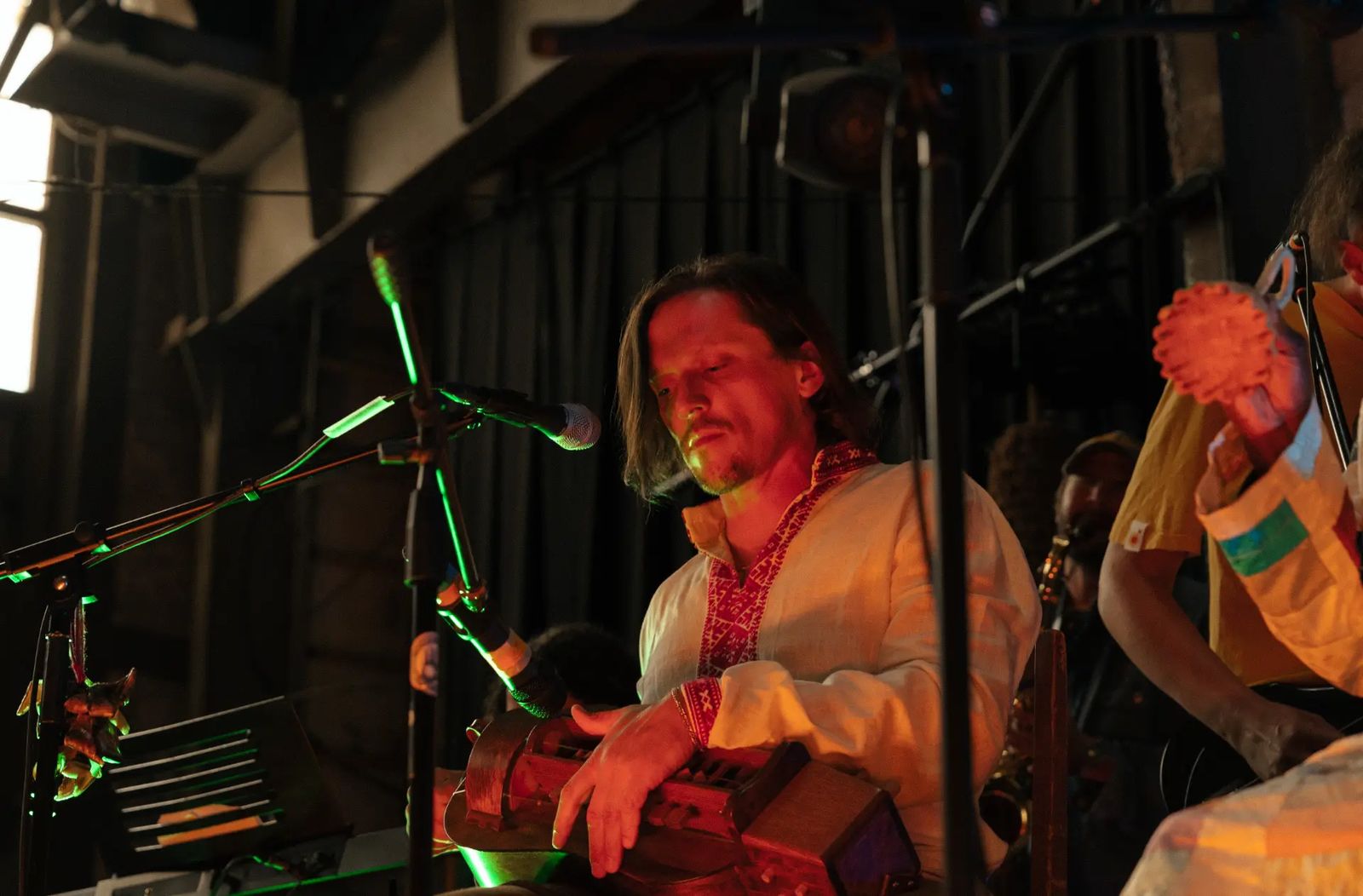 Siarzhuk Douhushau playing hurdy-gurdy on stage